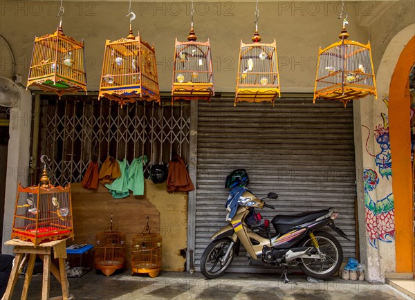 Motorcycle parked outside birdcage shop