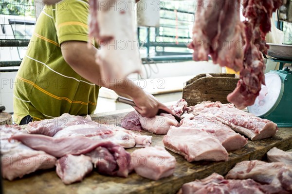 Butcher carving meat for sale in market