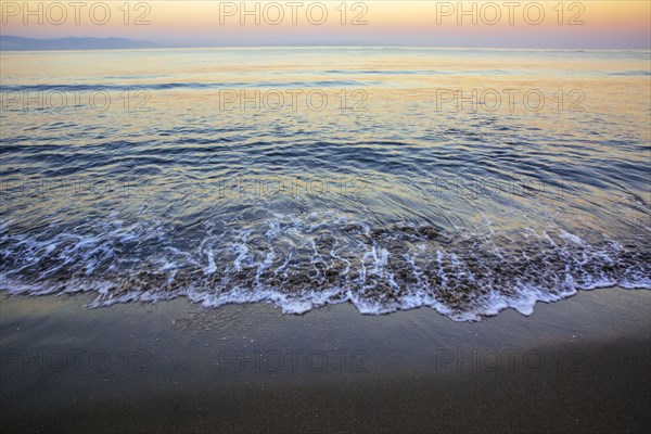 Waves washing up on sandy beach