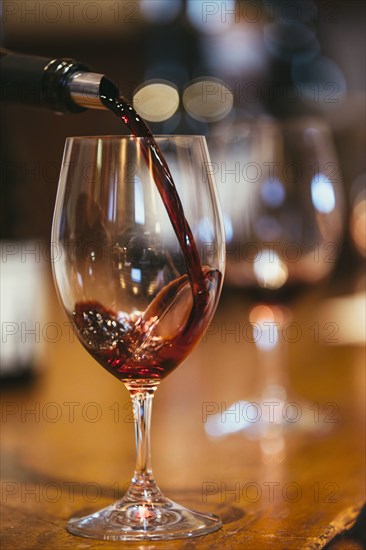 Close up of wine pouring into glass on table