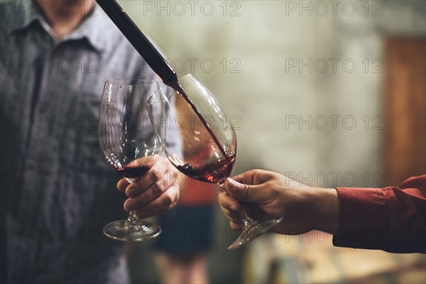 Caucasian men tasting wine in cellar