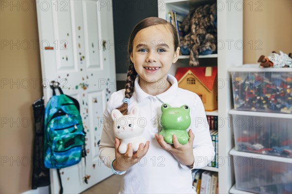 Mixed race girl holding toy animals