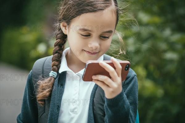 Mixed race girl using cell phone outdoors