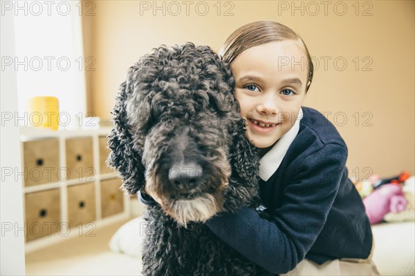 Mixed race girl hugging dog