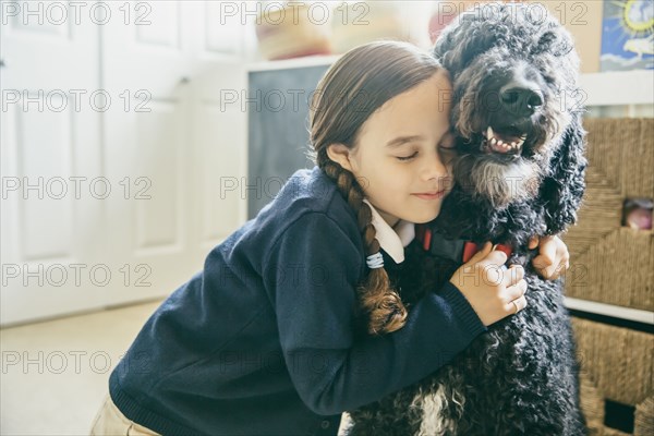 Mixed race girl hugging dog