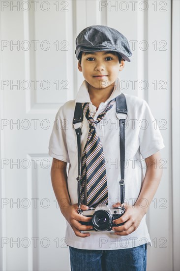Mixed race boy wearing camera on strap