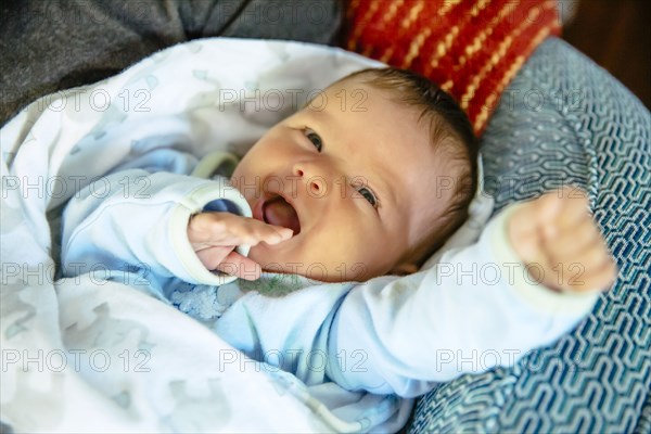 Caucasian baby boy laughing on sofa