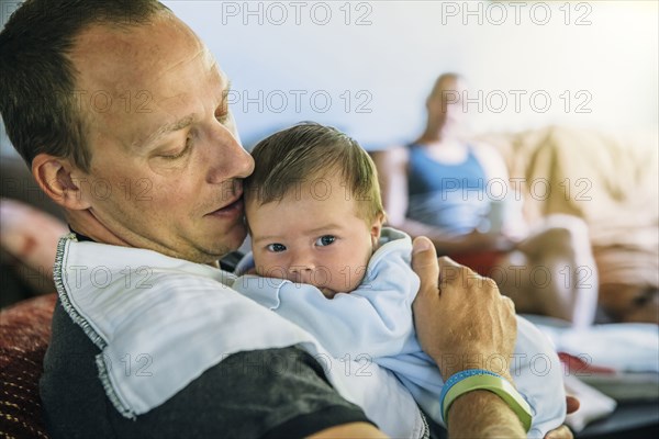 Caucasian father burping baby boy in living room