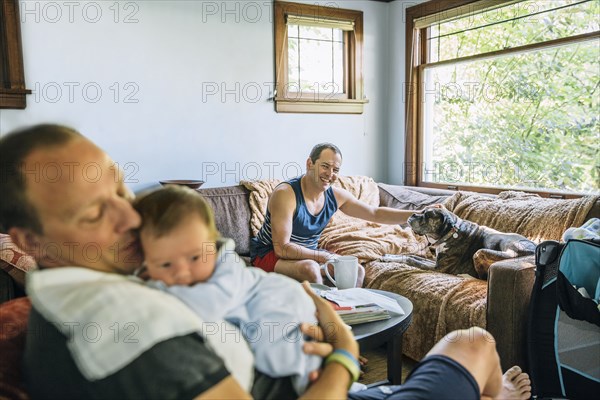 Caucasian fathers and baby boy relaxing in living room