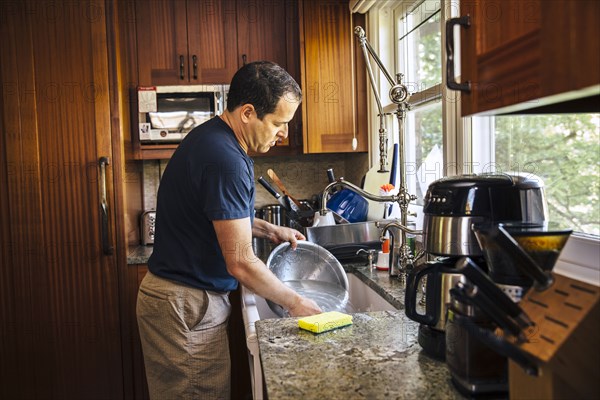 Caucasian man washing dishes in kitchen