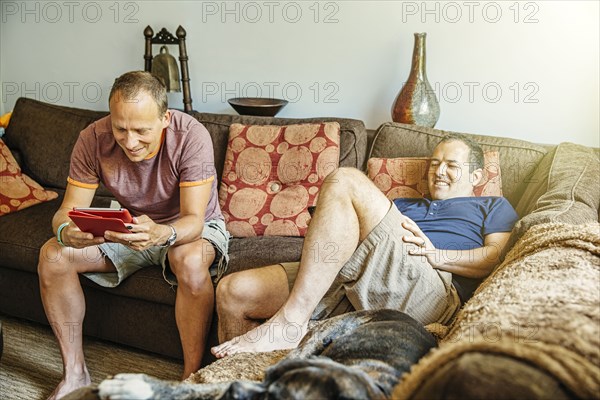 Caucasian gay couple relaxing in living room