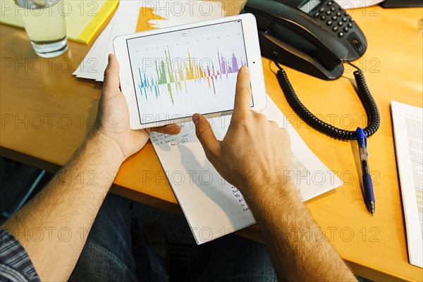 Businessman using digital tablet at desk