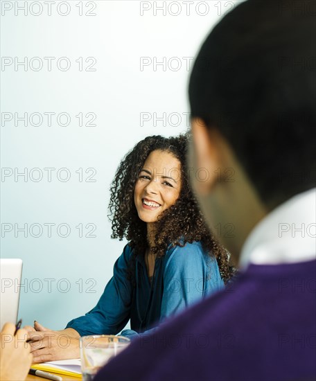 Businesswoman laughing in office meeting