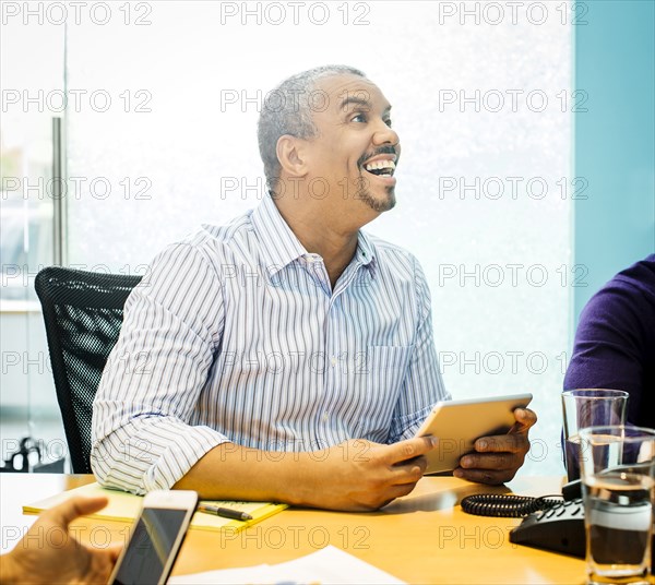 Businessman using digital tablet in office meeting