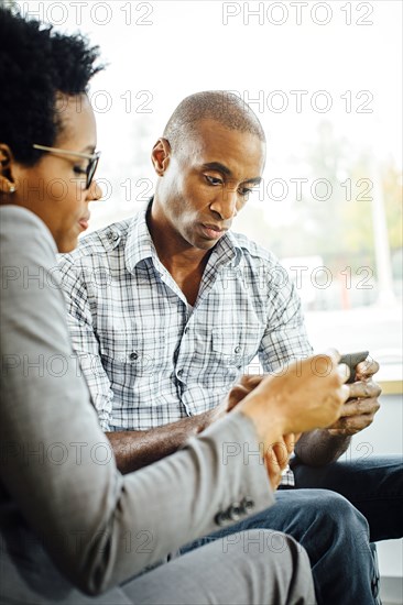 Black business people using digital tablet in office lobby