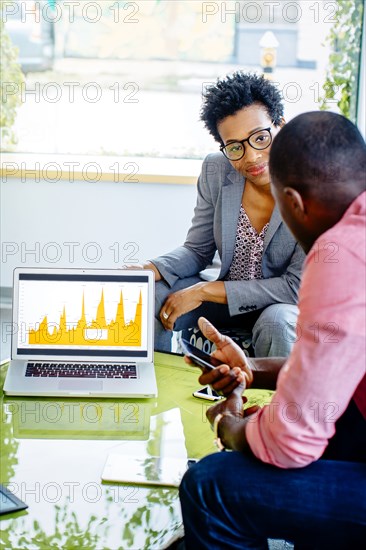 Business people using laptop in office lobby