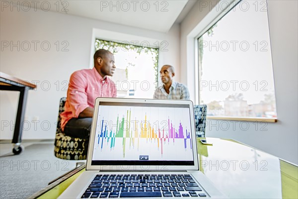 Businesswomen sitting behind laptop in office lobby