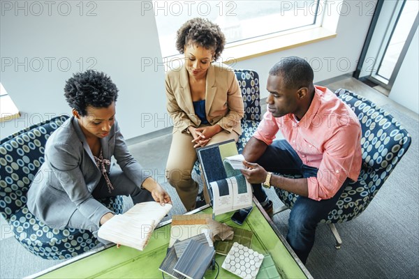 High angle view of business people examining swatches in office lobby