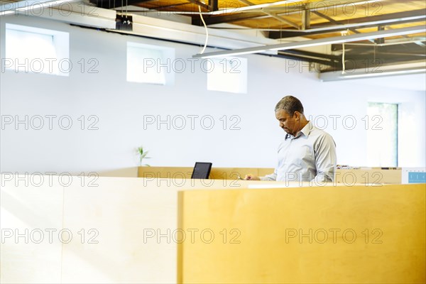 Black businessman standing in office cubicle