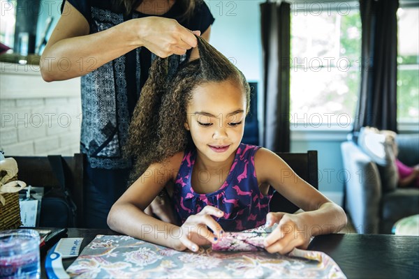 Close up of mother braiding hair of daughter