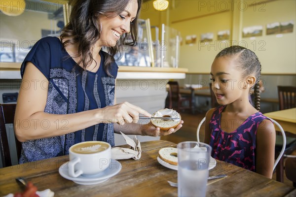 Mother and daughter eating breakfast in cafe