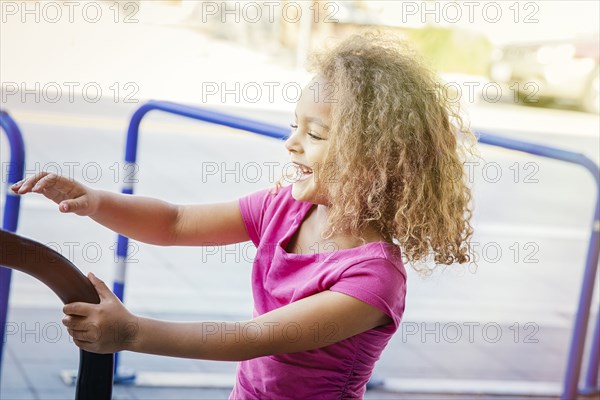 Mixed race girl playing on bicycle rack