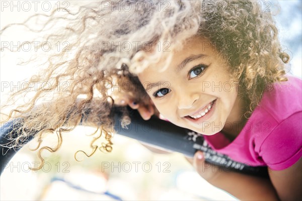 Mixed race girl playing on bicycle rack