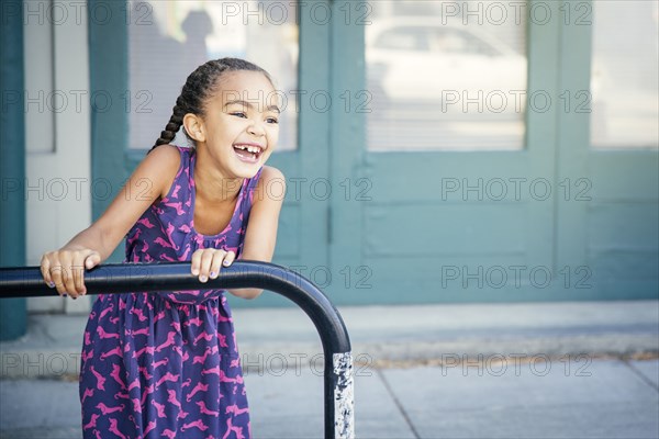 Mixed race girl playing on bicycle rack