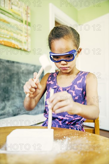 Mixed race girl doing science experiment at home