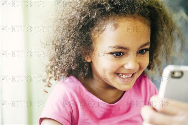 Mixed race girl using cell phone at home