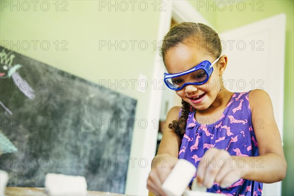 Mixed race girl doing science experiment at home