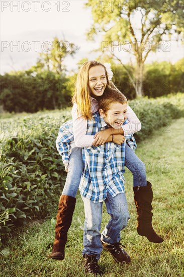 Caucasian children playing in crop field on farm