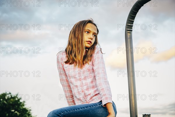 Low angle view of Caucasian girl sitting outdoors