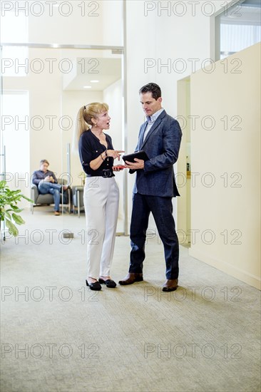 Business people talking in office hallway