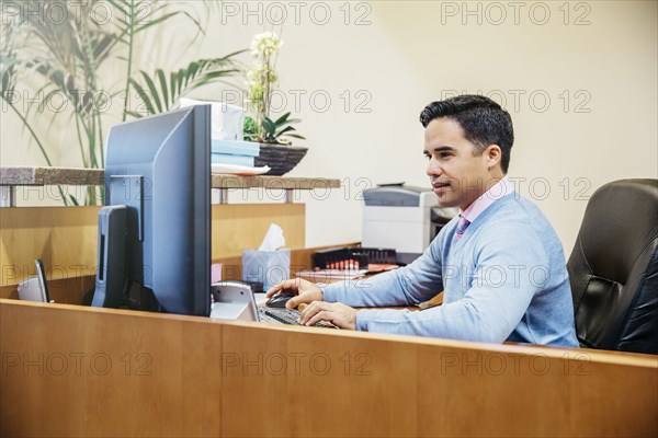 Mixed race secretary working in office lobby