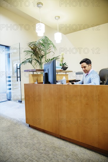 Mixed race secretary working in office lobby