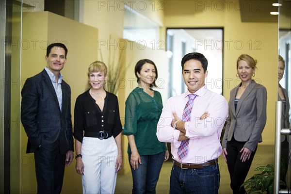 Business people smiling in office hallway