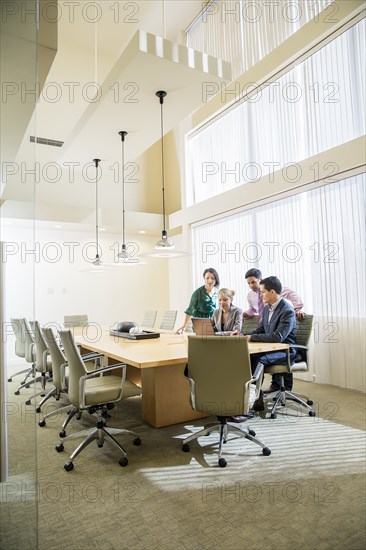 Business people using laptop in office meeting