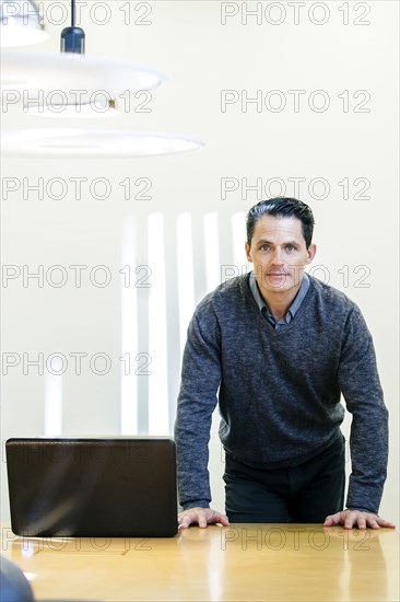 Mixed race businessman standing at conference table