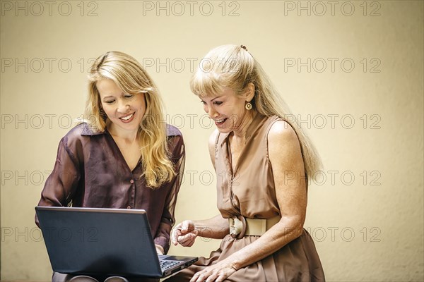 Businesswomen using laptop together in office