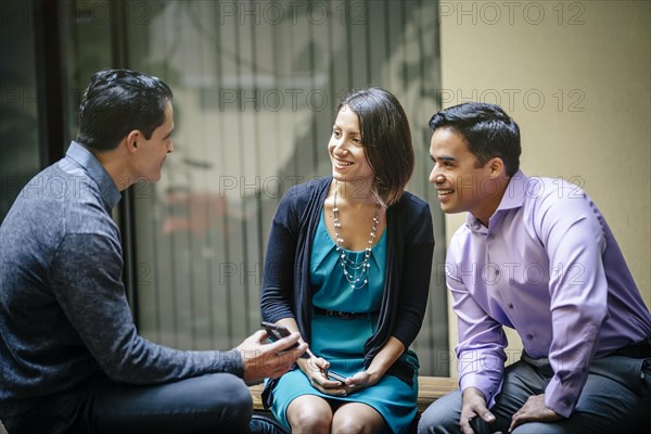 Business people using cell phone in office courtyard