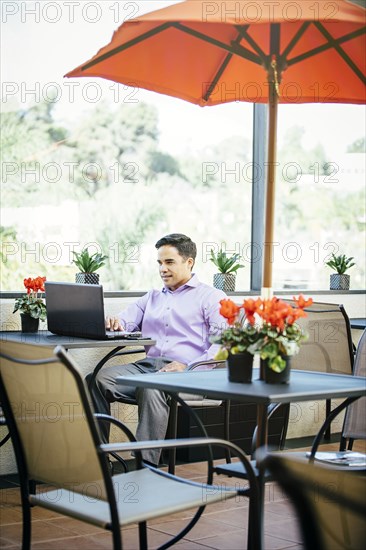 Mixed race businessman working in cafe