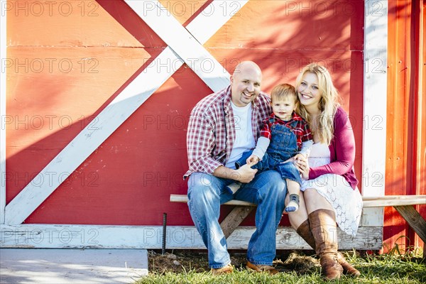 Caucasian family smiling outside barn