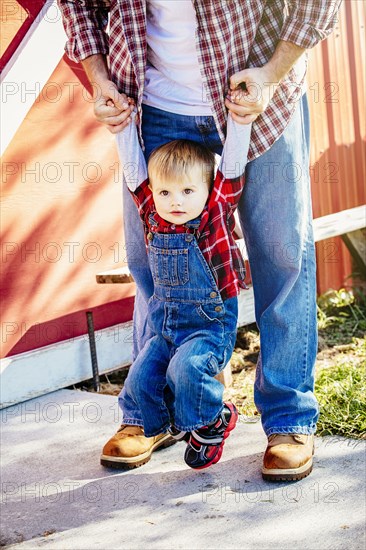 Caucasian father and son playing outside barn