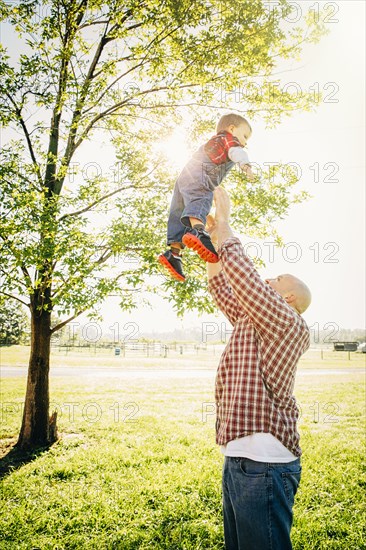 Caucasian father and son playing on farm