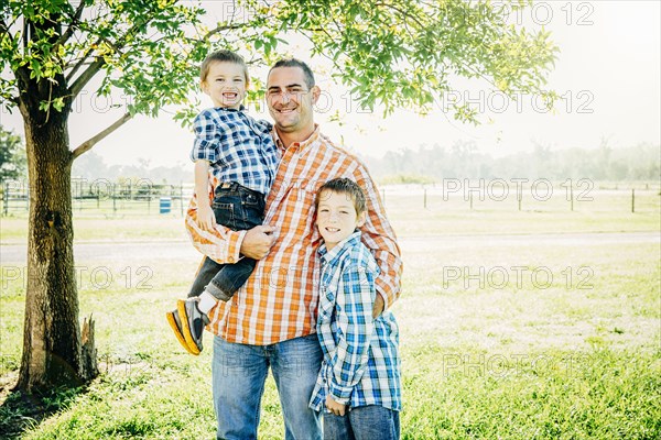 Father and sons smiling on farm