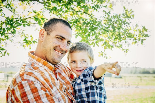 Father and son pointing on farm