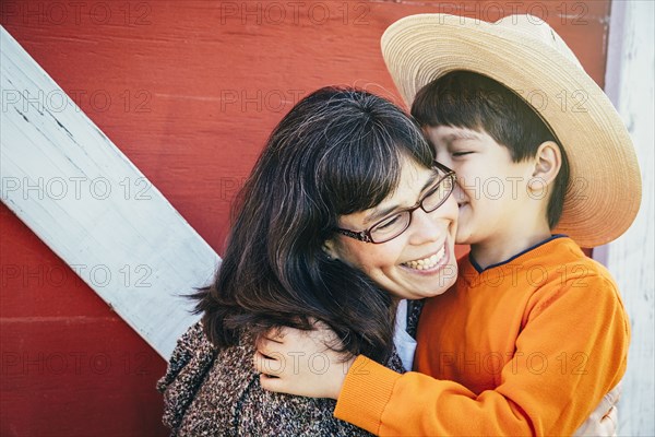 Caucasian boy kissing cheek of mother
