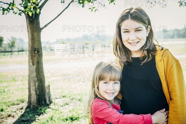 Caucasian sisters smiling on farm