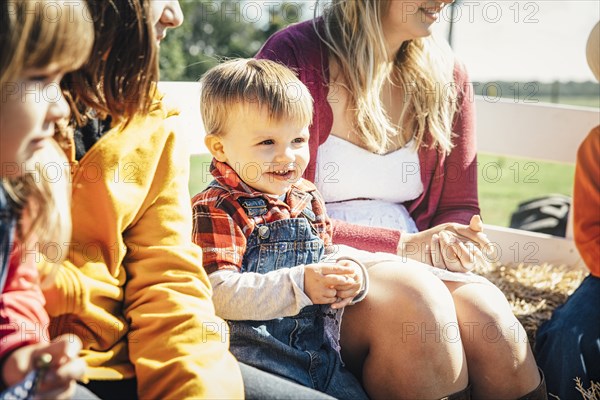 Caucasian family sitting on hay ride